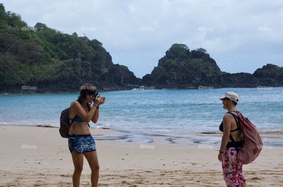 Woman talking a picture in the beach. Fernando de Noronha island. Brazil 