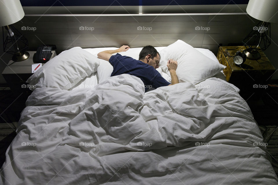 Sleeping on your stomach can be bad for your back, regardless of how comfortable the hotel bed may be. 
