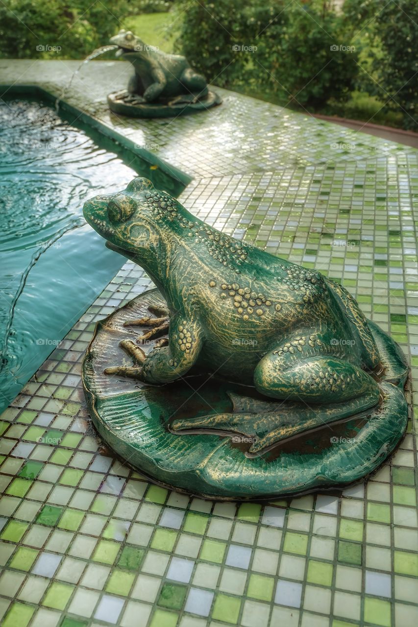 A fountain with green frogs.