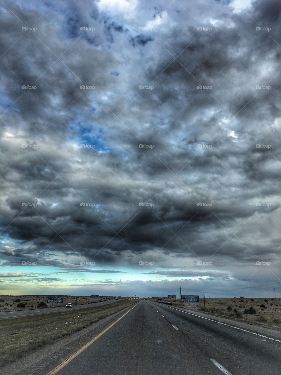 The grey road goes on underneath a grey sky. Traveling is a happy story 