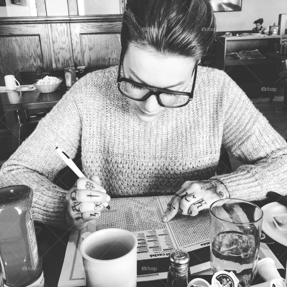 My love doing crosswords during breakfast at the restaurant