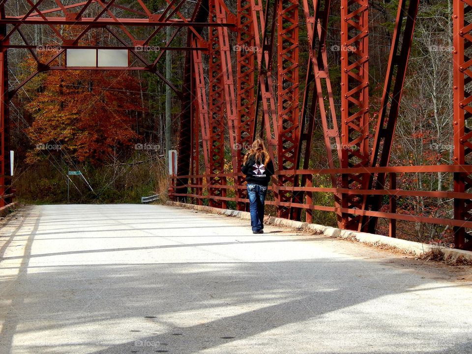 girl walking on old bridge in fall