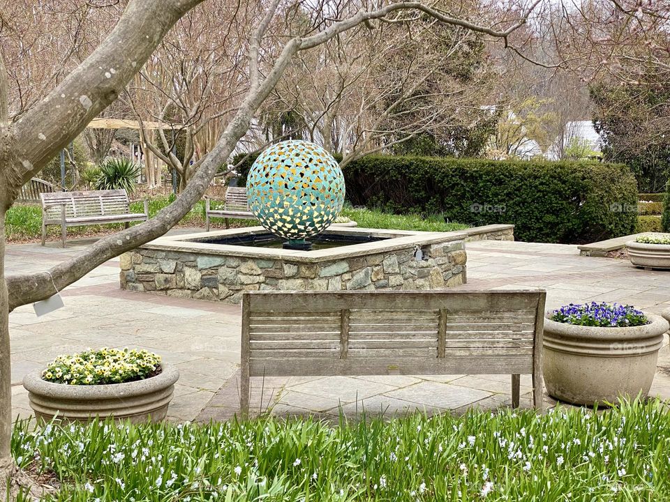A metal sculpture and benches in a local garden