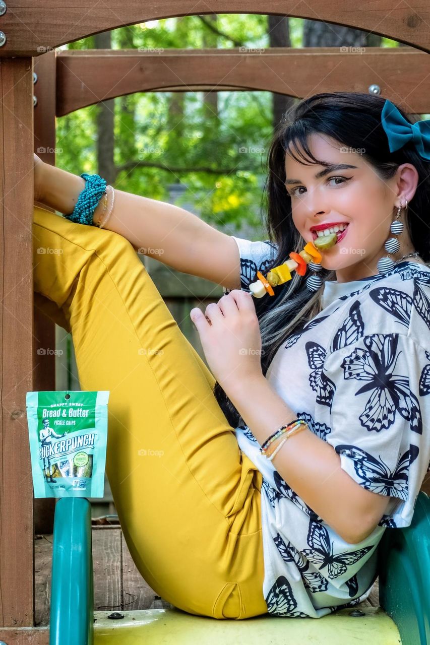 A vibrant young lady is sure enjoying her pickles! 