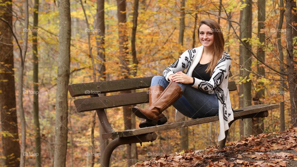 Woman sitting on bench in forest