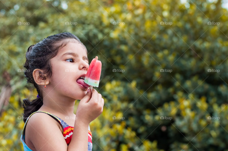 Young girl enjoying watermelon popsicle during hot summer🌞