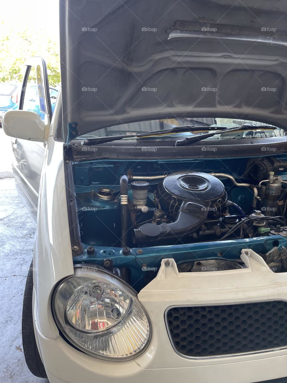 Under the hood of a mini car. Close up view of the engine running while fixing.