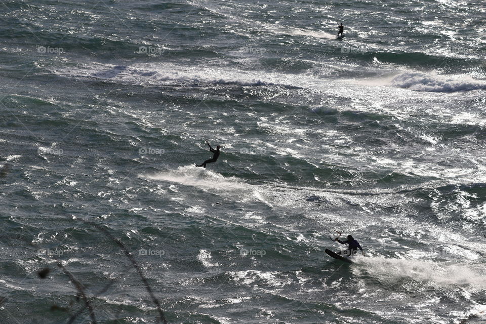 Windsurfing in the ocean sparkling on the light of a bright winter sun