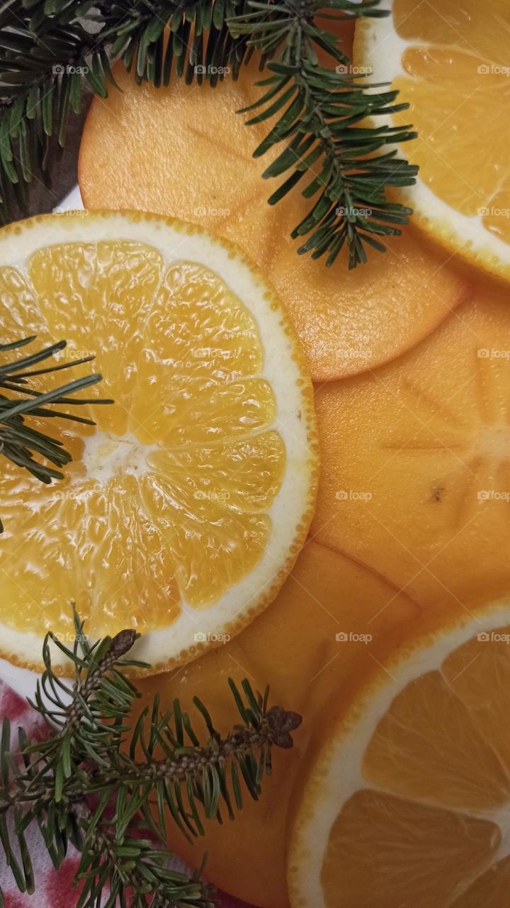 Christmas and New year mood. Persimmons, oranges and Christmas tree