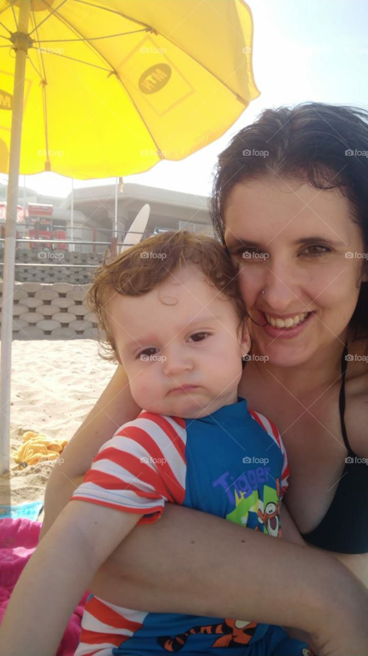 My beautiful wife and son enjoying the beach, although his face seems to convey a different message. That's the face you get when you take away his Coca-Cola. By the way, today was his very first time experiencing the beach 😁❤