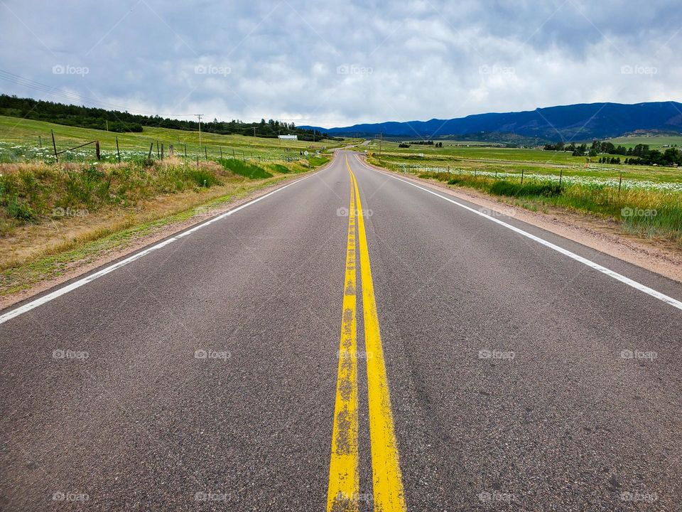 A long ribbon of deserted road cuts through beautiful countryside