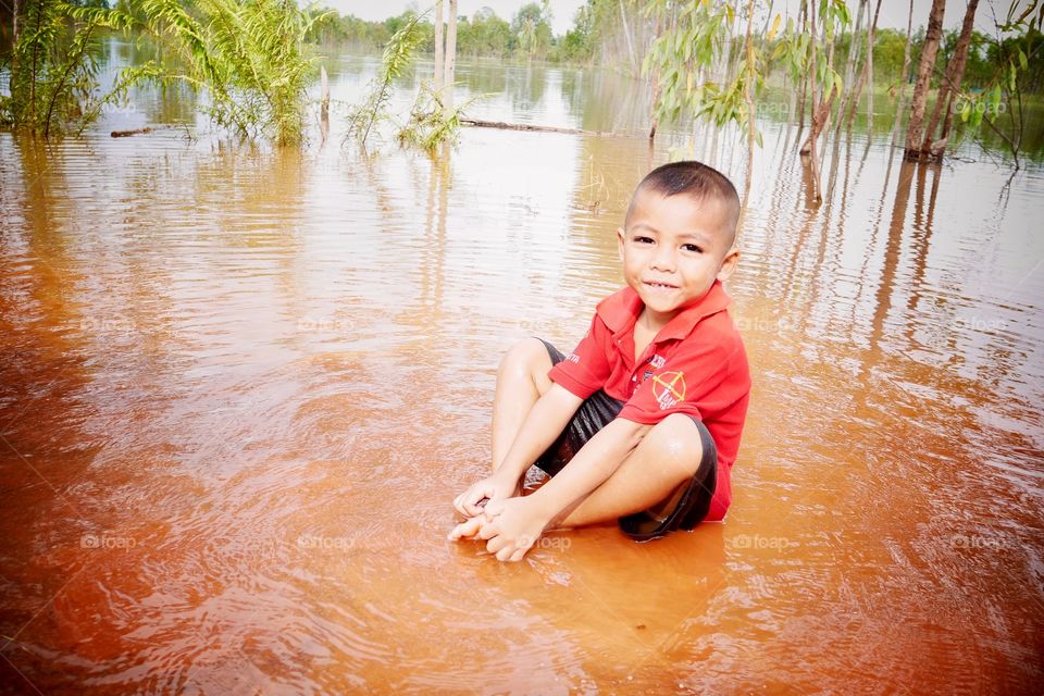 Little boy sitting in water
