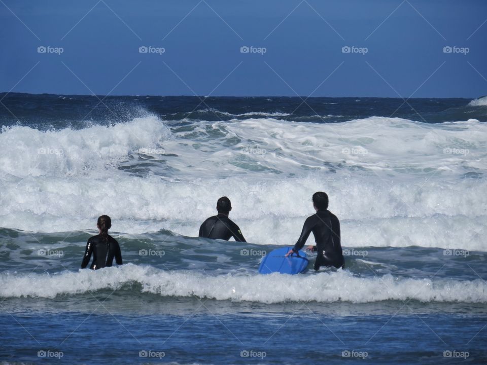 Kids just newly schooled in the ways of surfing heading out to catch a wave or two. 