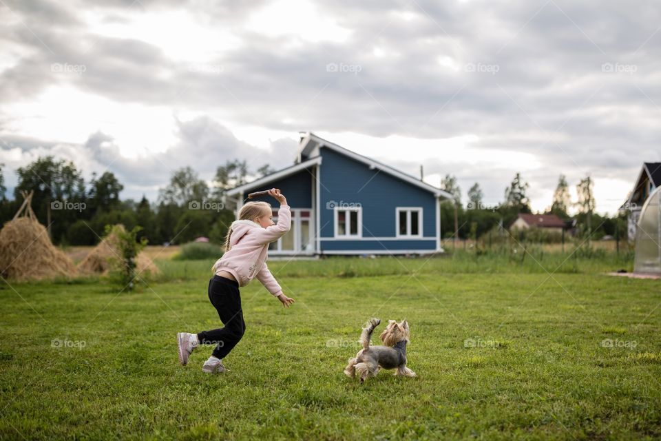 Kid playing with dog on backyard 