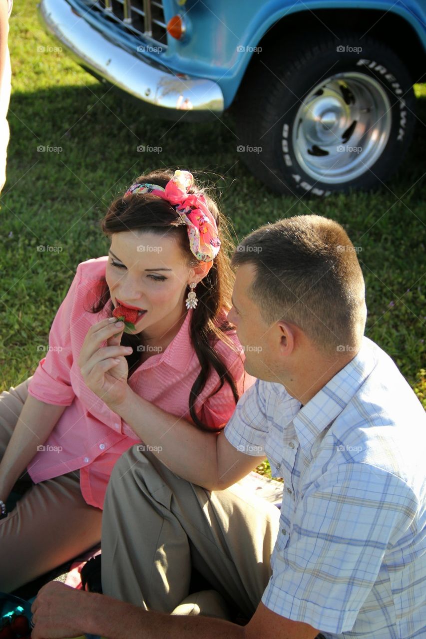 Time to relax . A couple relaxing while sharing strawberries in the nice spring weather