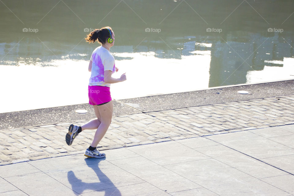 Woman jogging in the evening at river bank, Pittsburgh, PV