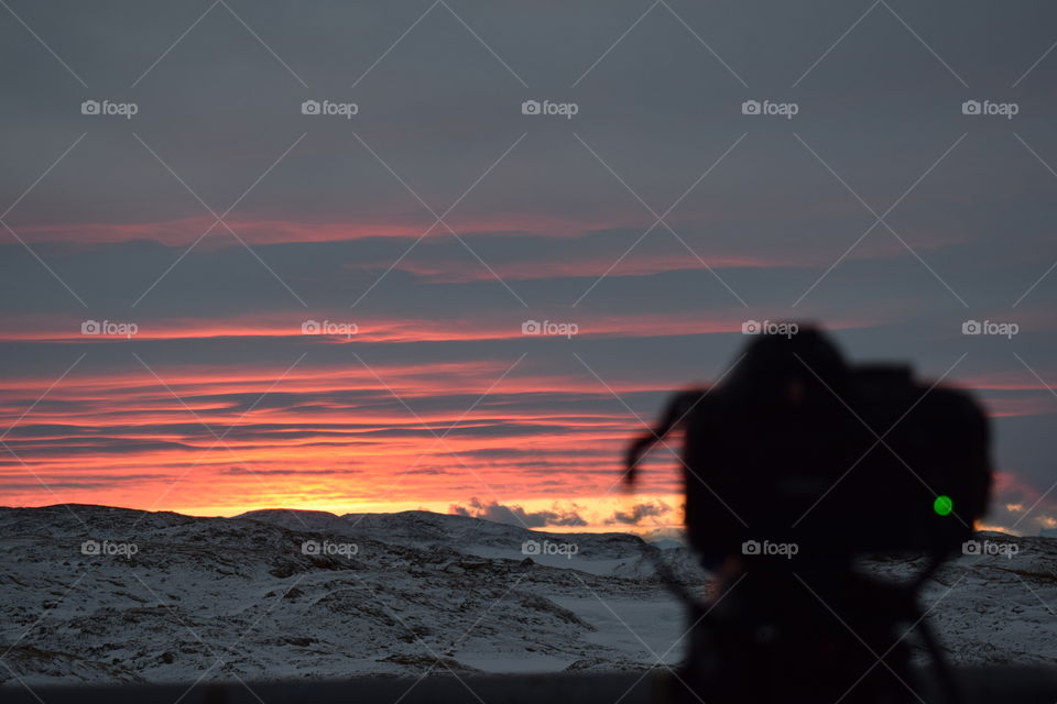 Sunset at South Pole and a dslr camera which is not in focus with a brightly lit background 
