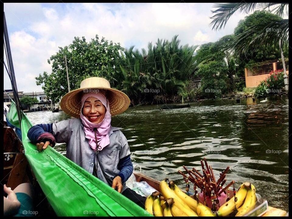 Woman selling fruit at floating market in Thailand.