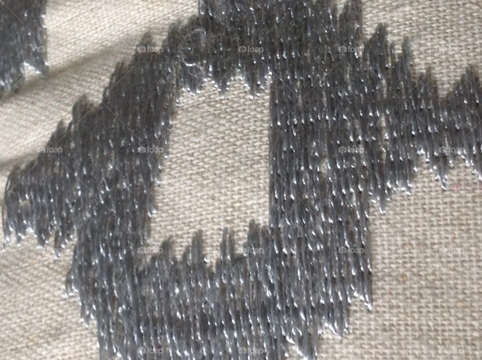 Threads on a fabric pillow.