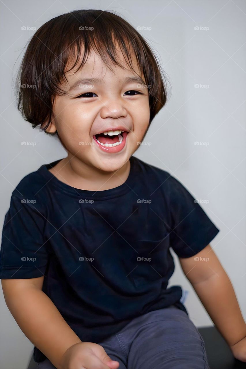 handsome asian boy laughing happily playing in childhood