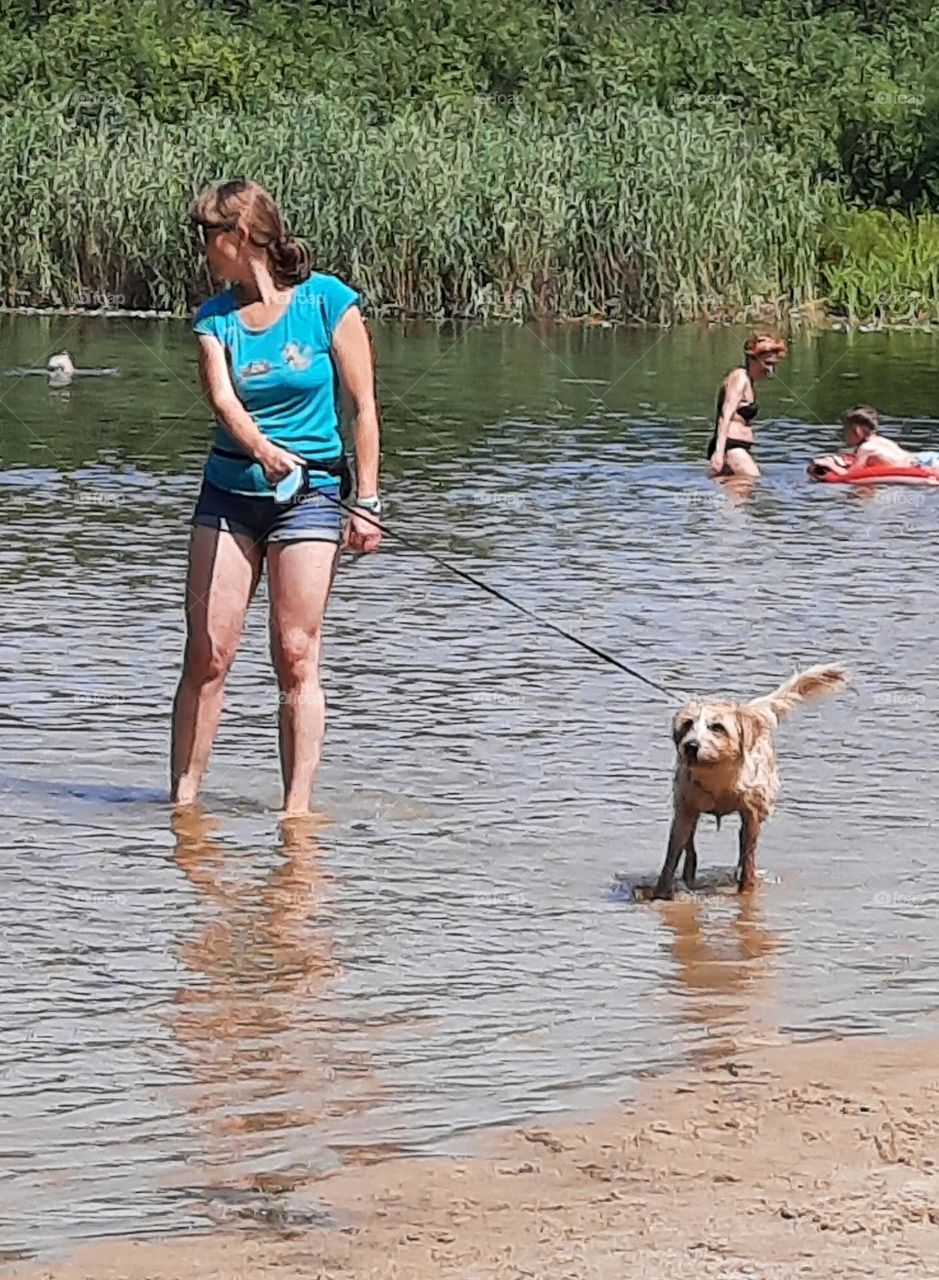 suprised woman with a dog in a pond