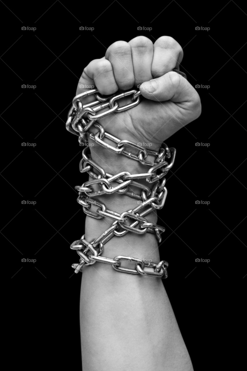Fist of man in chains. Black and white