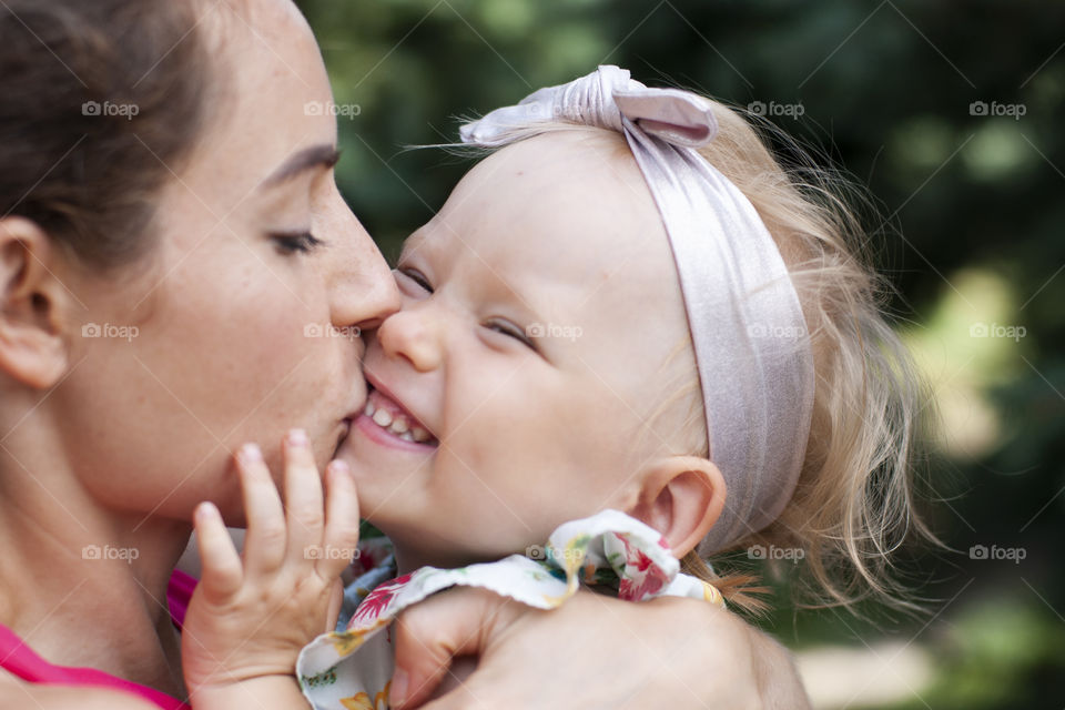 Happiness is a mom's kiss. Mom kisses daughter