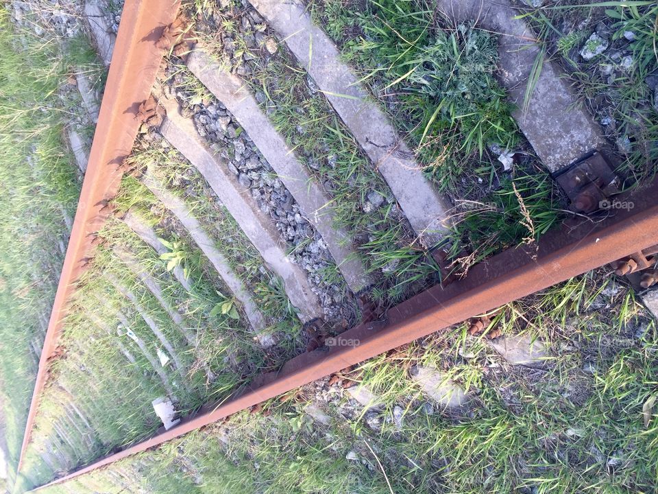 Rusty railway with grass twisted