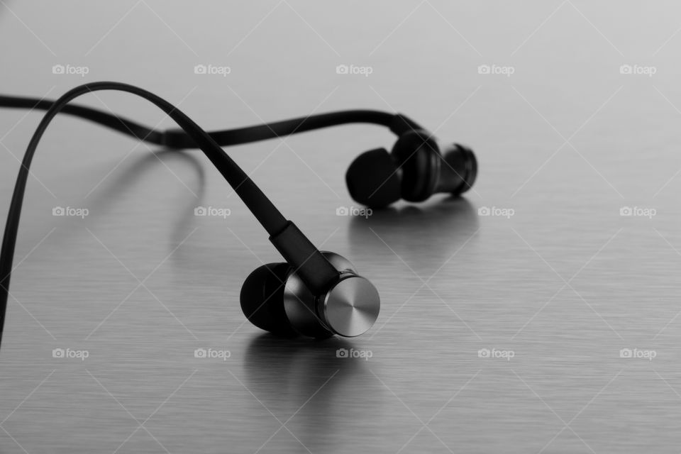 Black earphones on brushed steel background