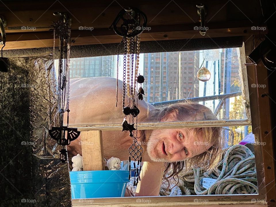 The man with the winning smile is “Timothy Trespas” my partner for many years. He looks into the window of “Salvation”, our “28 ft 1969 Luhrs” at “Newtown Creek” LIC, Queens after successfully completing some repairs. 2023. Hypnotic Productions