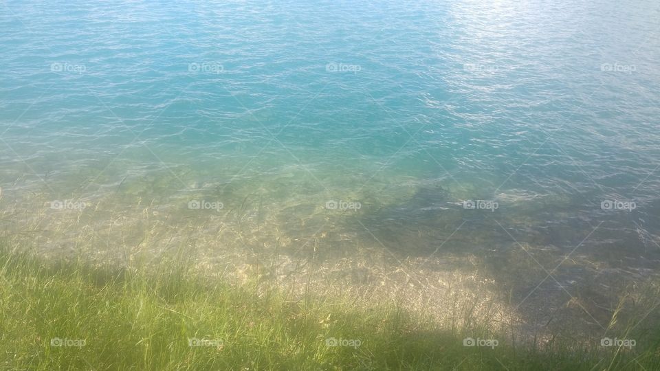 Beautiful clear blue water transparent and green grass