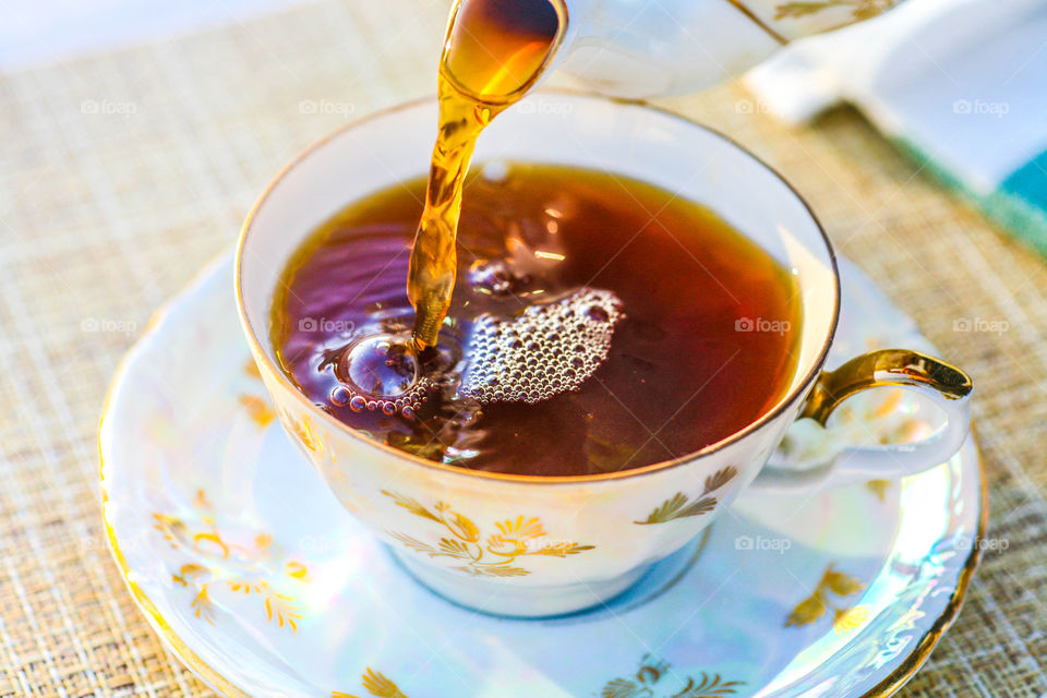 Black tea pouring in the cup