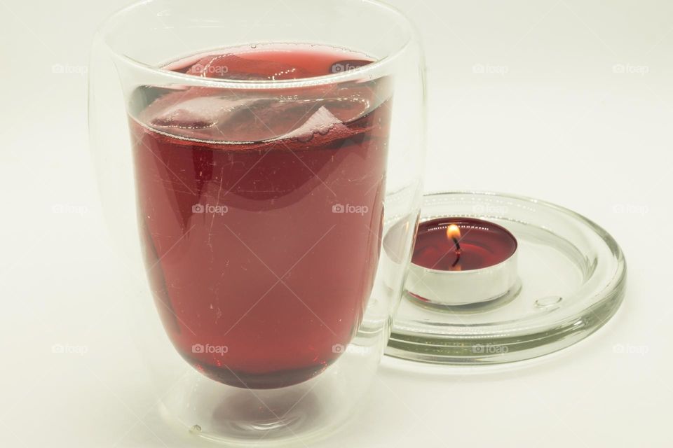 Cup of hibiscus tea and candle. Viva magenta