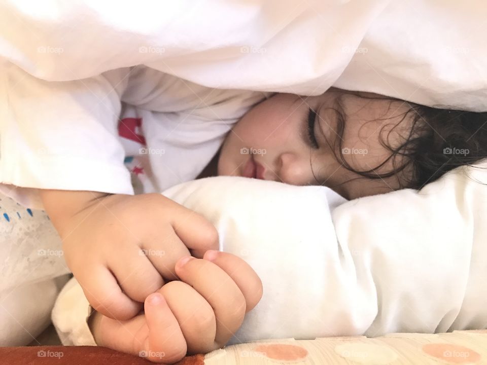 Cute baby girl lying on bed