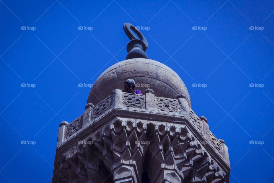 Islamic architecture. A man taking a photo from the highest point of the minaret.