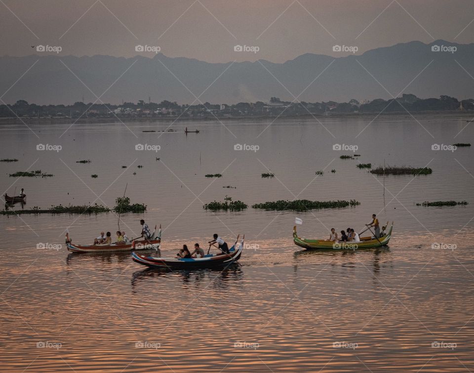 Myanmar guide tourists in boat to see local life at U bein bridge , the most longest wooden bridge in the world