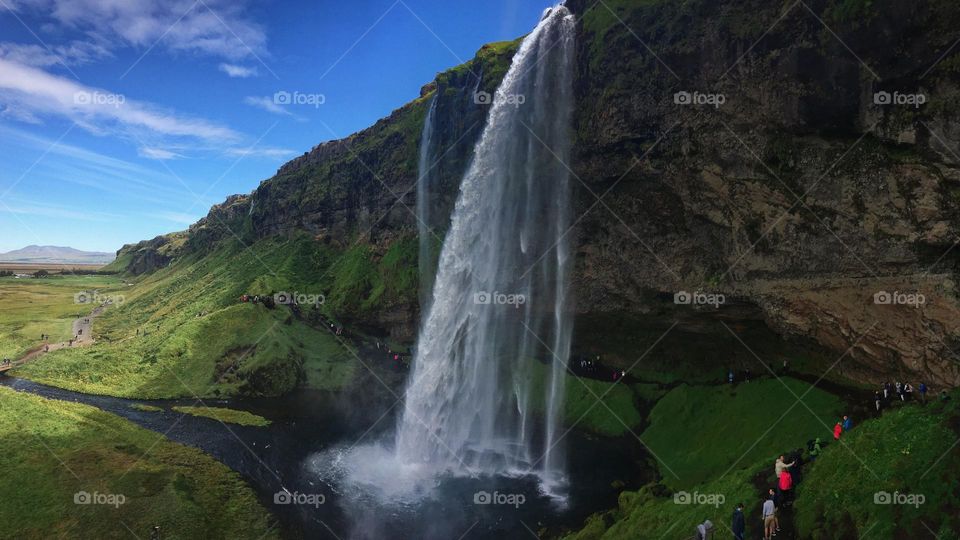 Hikers are enjoying their walk by the beautiful waterfalls.