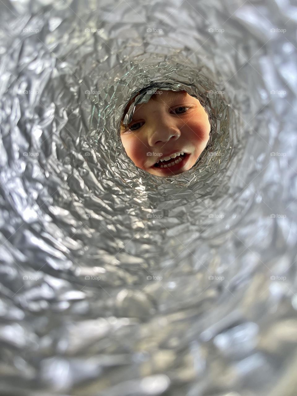 Through the eyes of a Sweet, Little toddler playing with Dryer hose using it as a telescope 