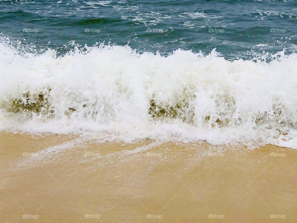 Crashing waves tumbling onto the warm sand 