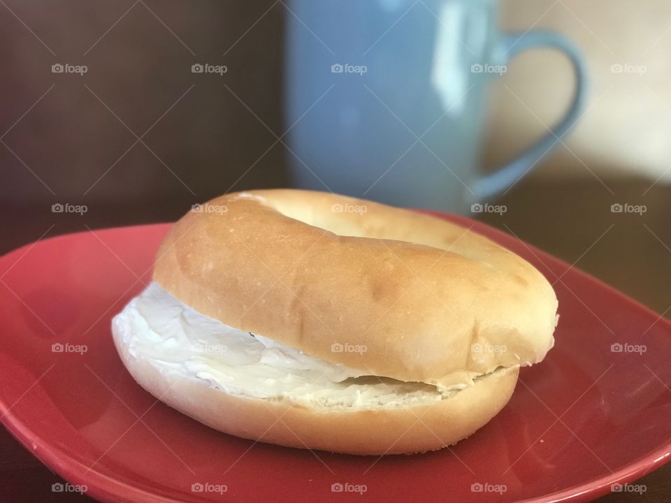 Delicious bagel with cream cheese and coffee mug