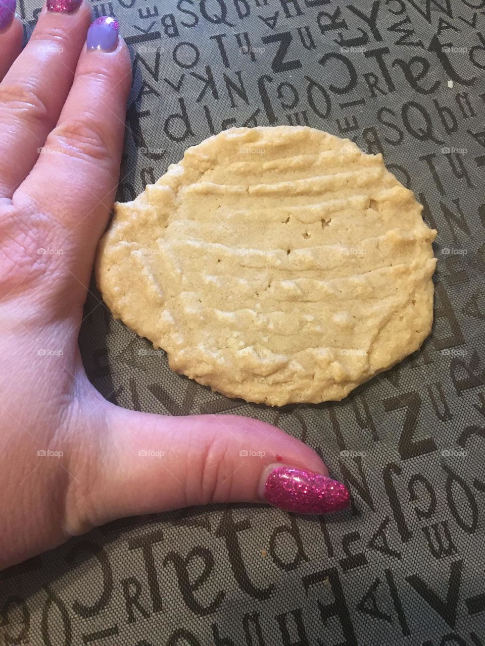 Middle aged lady hand extended, shows how big her cookies are