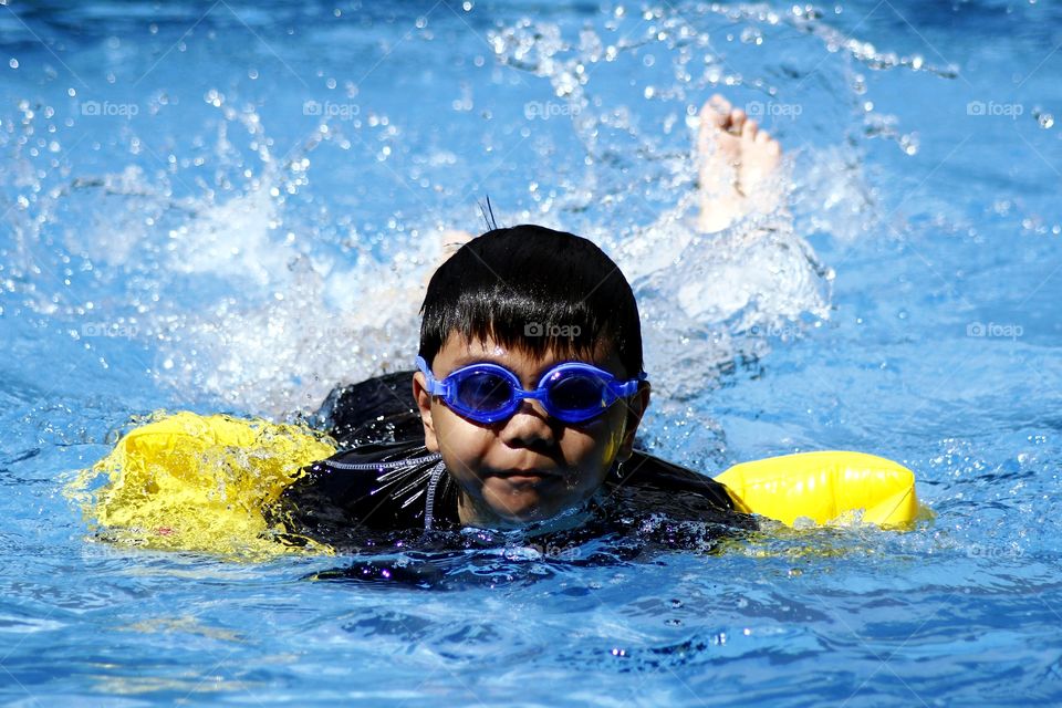 young kid swimming in a swimming pool