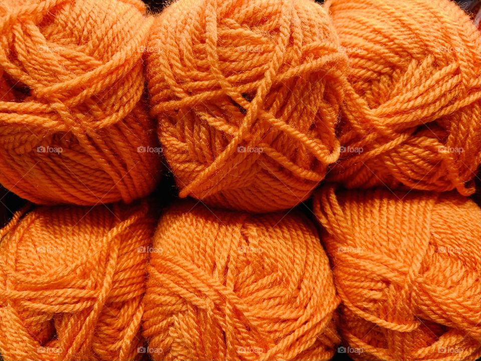 Set of orange wool yarn balls close up, knitting material, hand made creations 