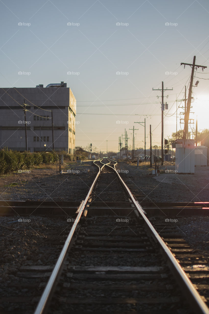 A picture of a railroad in a small town at sunset
