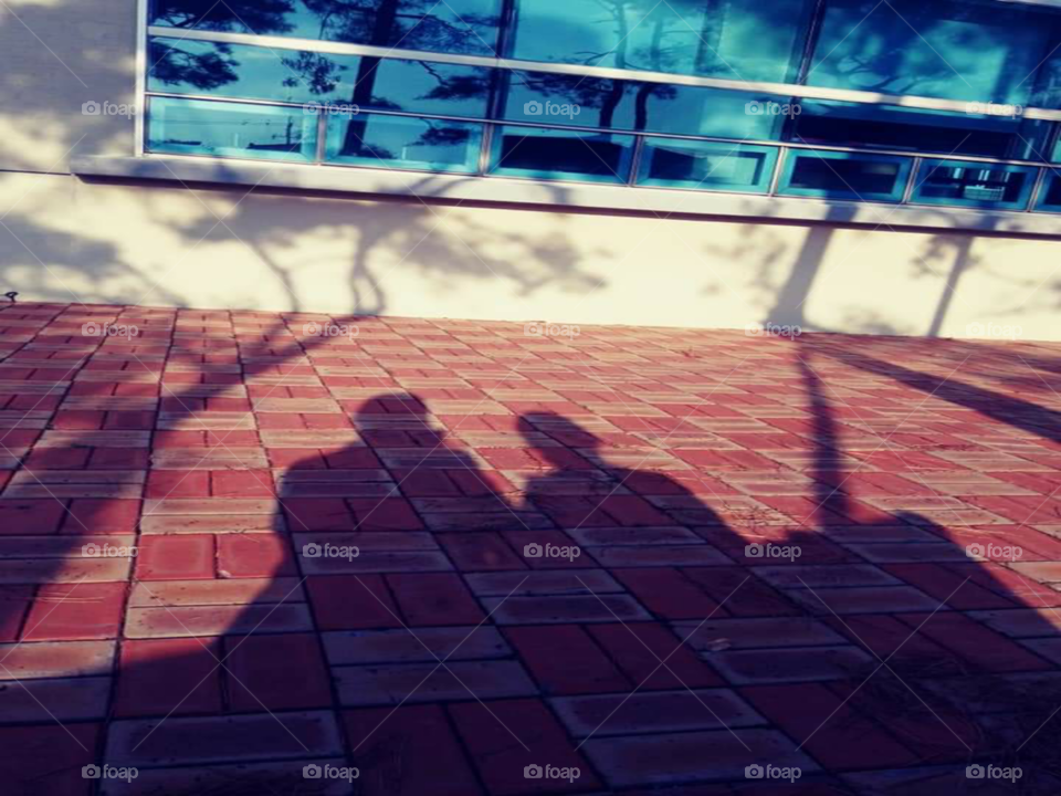 a shadow of a mother and child sitting together while listening some music.