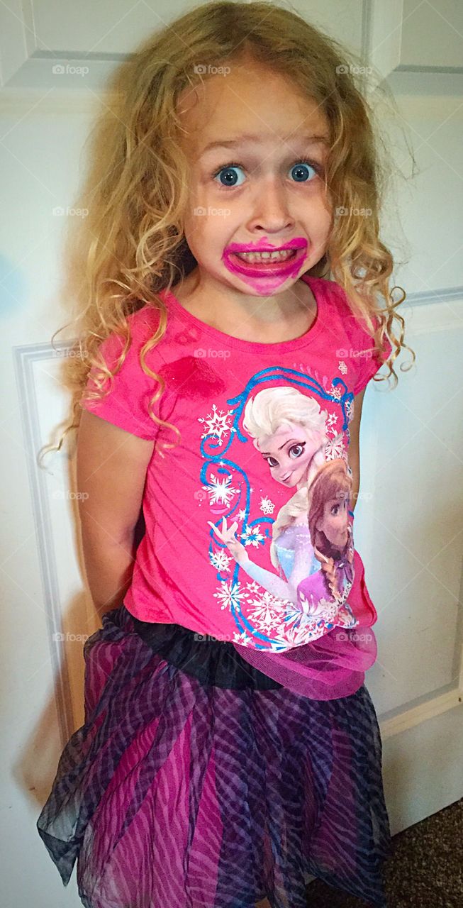 Little girl with lipstick on face