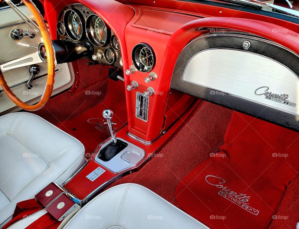 A beautifully restored 1960's Chevy Corvette has a dashboard that is iconic and a classic design