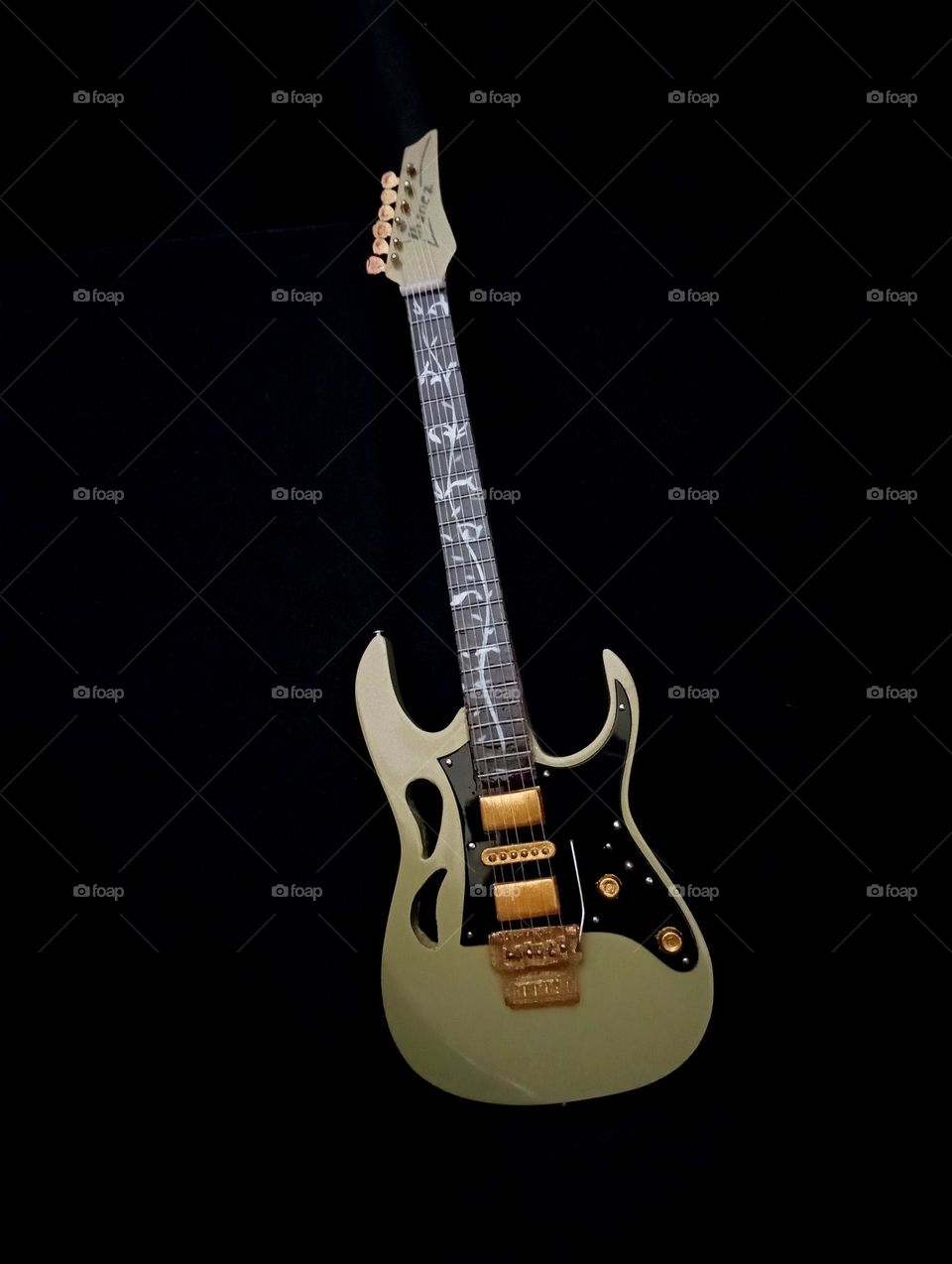 mini guitar replicas in a dark background