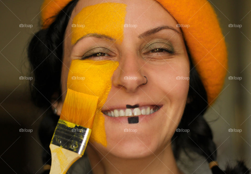 Portrait of painter woman in yellow color, close up smiling face