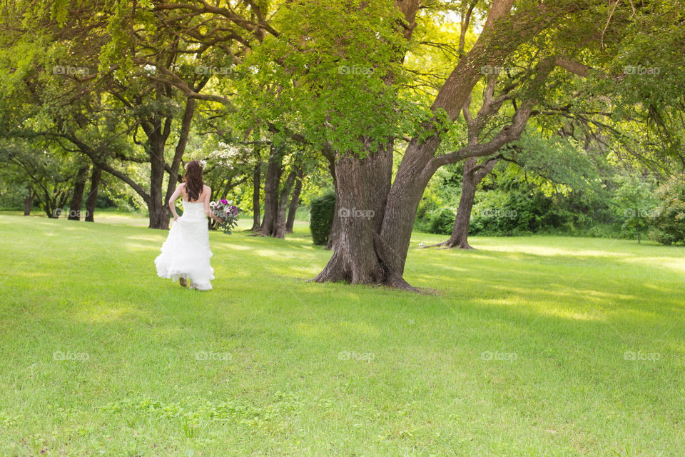 Runaway  Bride. On the walk to take bridal portraits, the bride looks as if she's trying to escape into the woods. 